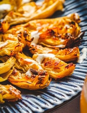 Closeup shot of roasted artichoke hearts with charred edges.