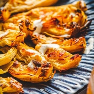 Closeup shot of roasted artichoke hearts with charred edges.