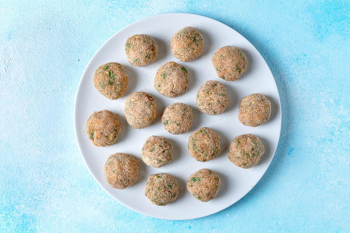 uncooked chicken piccata meatballs on a plate.