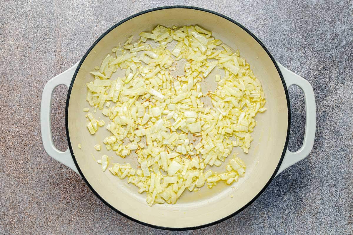 chopped onions being sauteed in a pot.