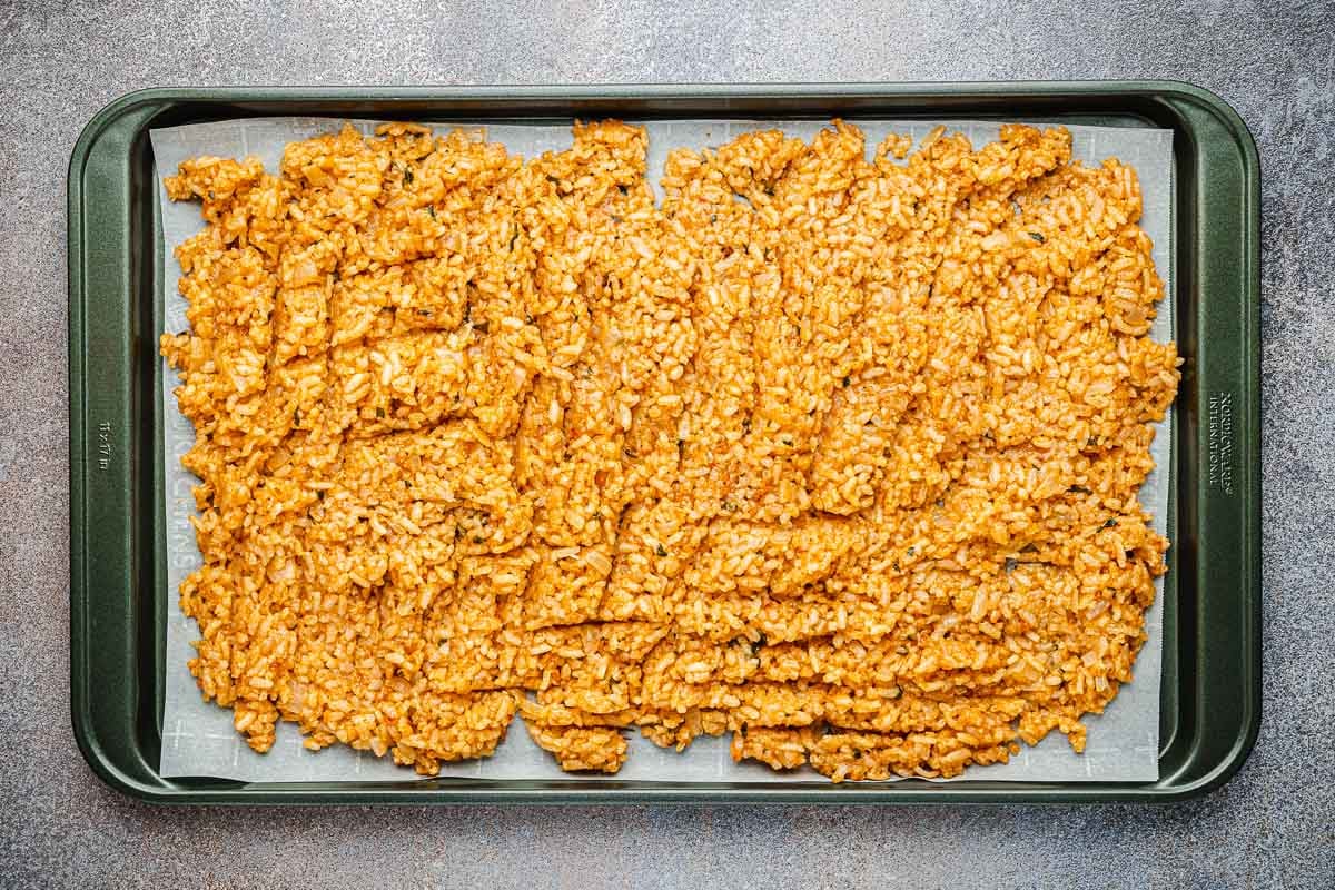 cooked arborio rice spread on a parchment lined sheet pan to cool.