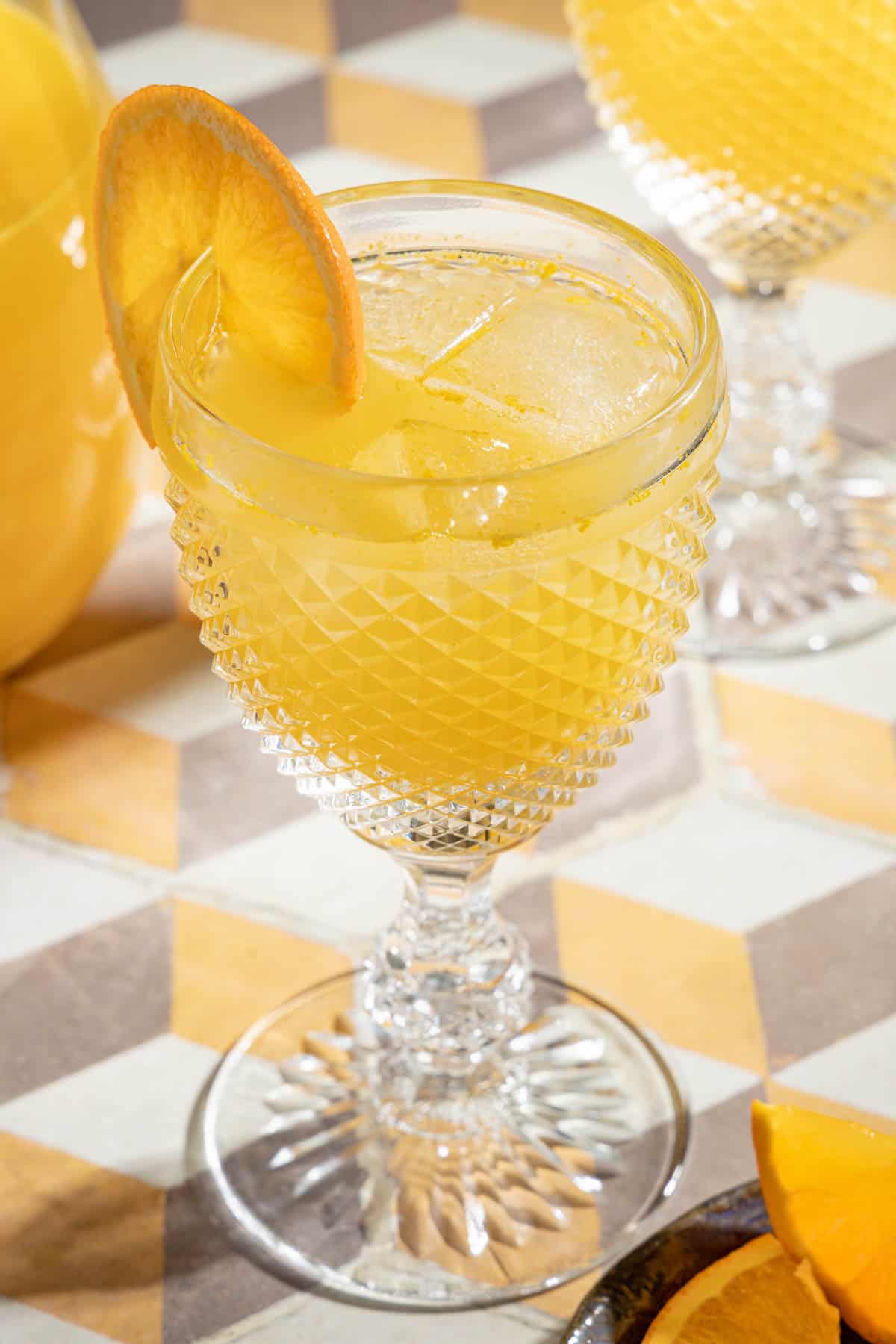 one glass of agua de valencia garnished with an orange slice.