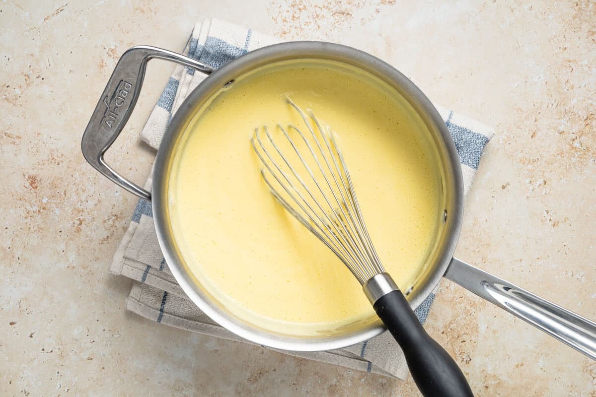 Crema Catalana being cooked in a saucepan until thick.