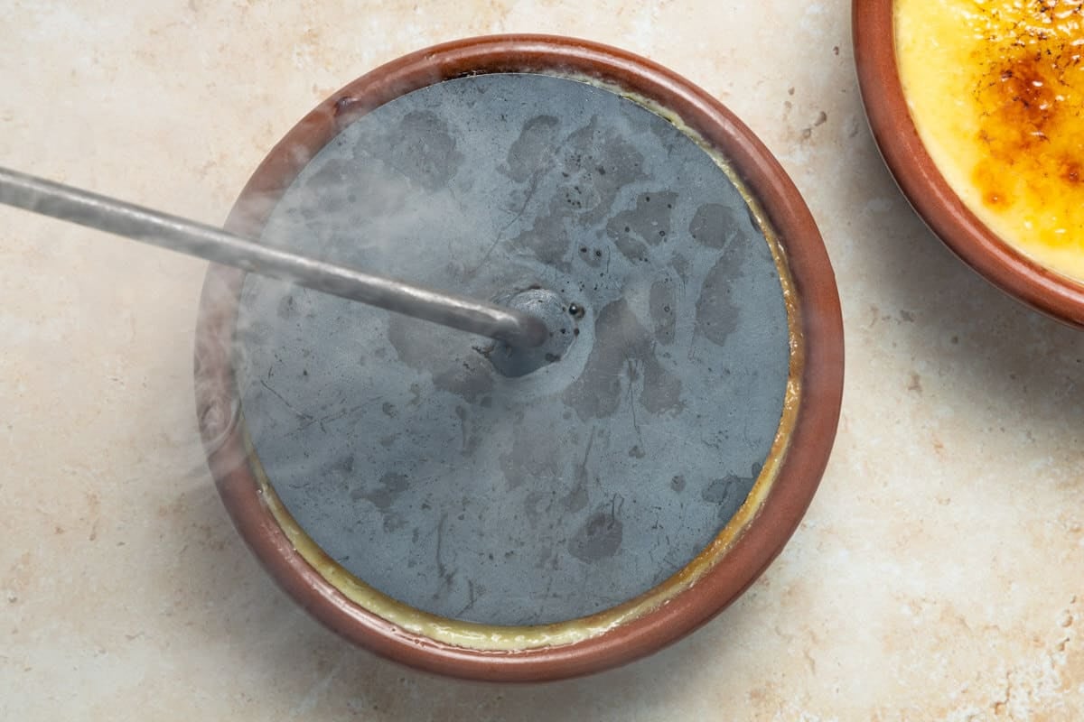 Crema Catalana being caramelized with a pala.