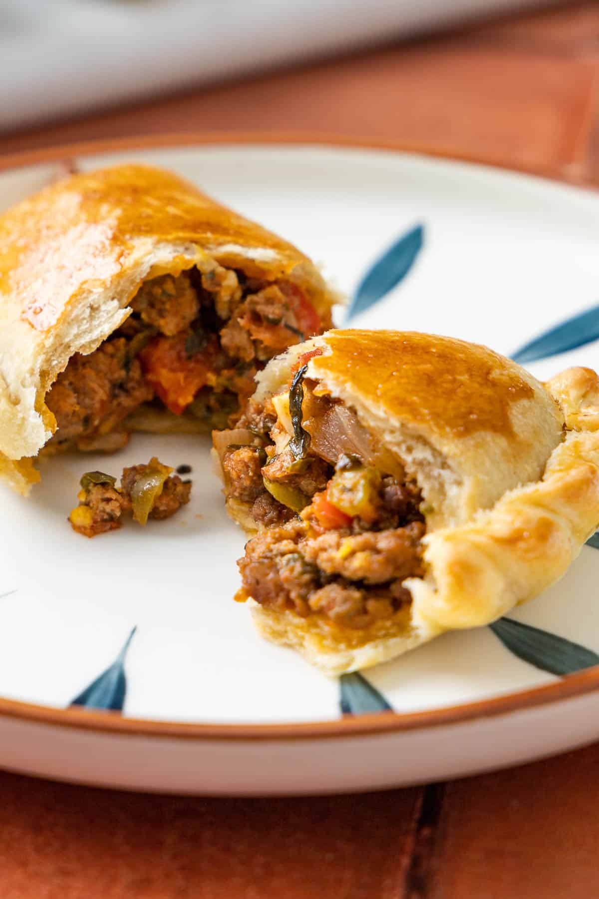 2 spanish beef empanadillas halves on a plate.