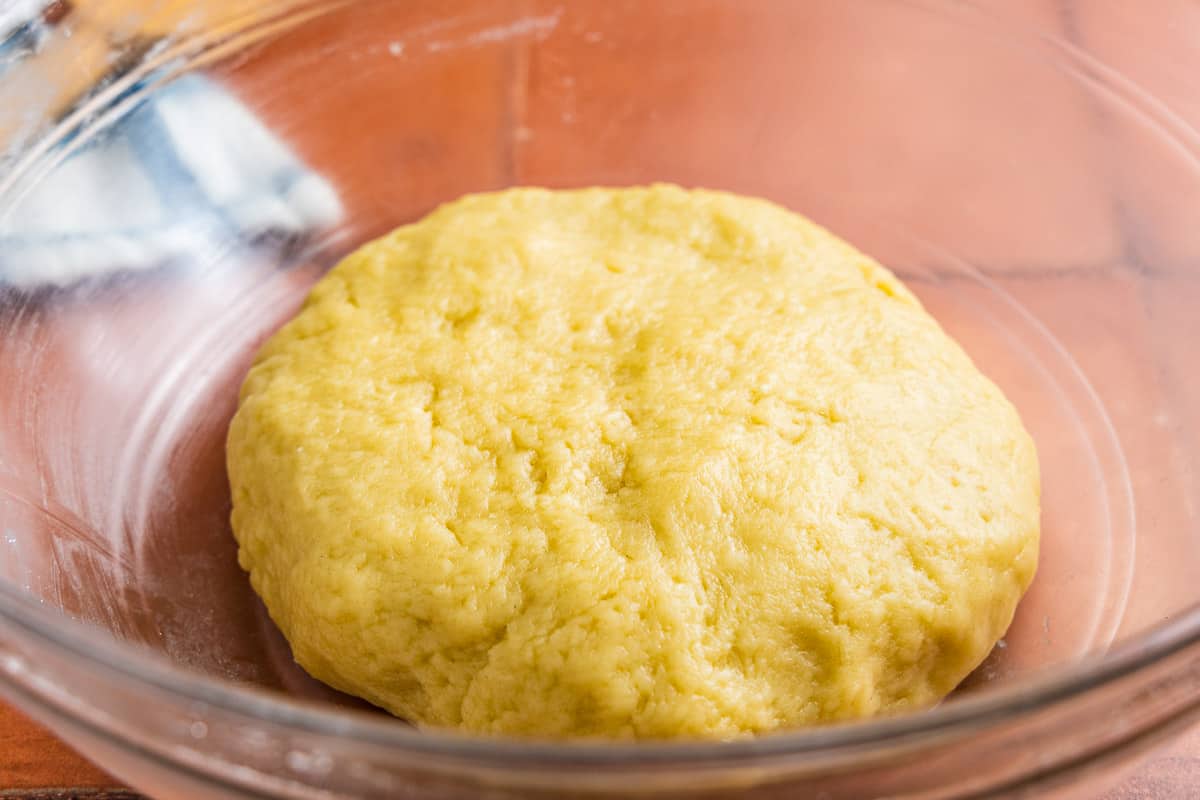 empanadilla dough resting in a glass bowl.