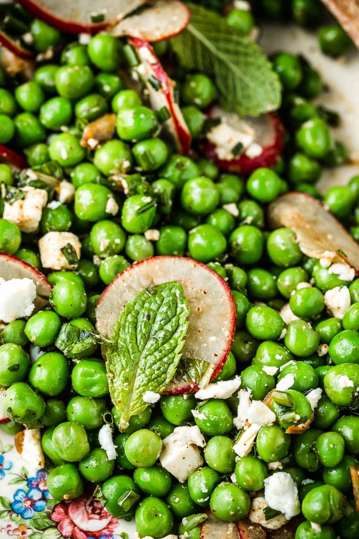 close up of spring pea salad with sliced radishes and mint.