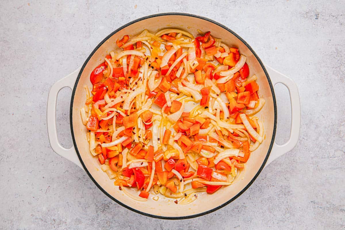 onion, garlic, red bell pepper and red pepper flakes sautéing in a skillet.