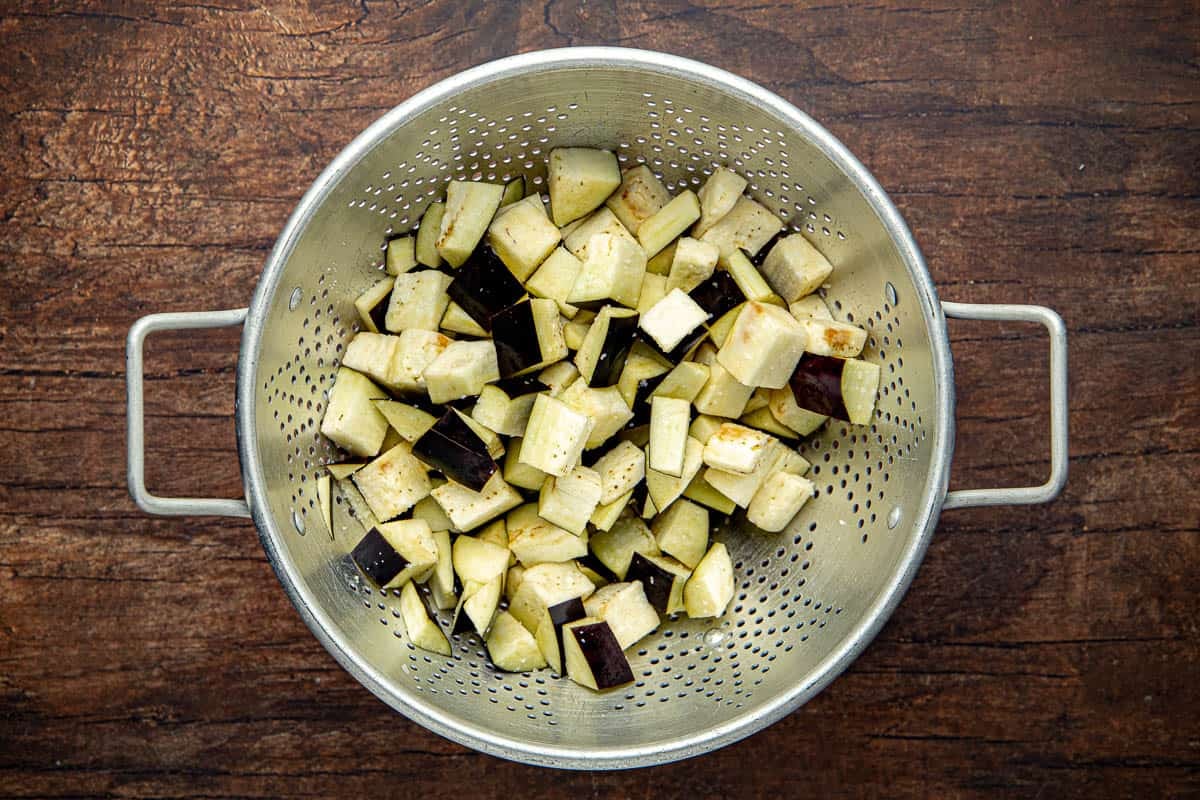 Sliced eggplant in a colander.