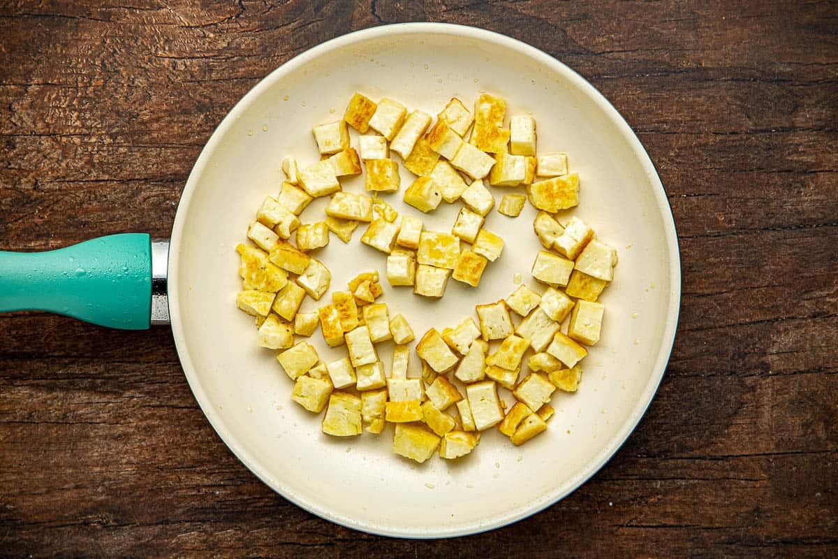 Cubed halloumi cheese in a frying pan.