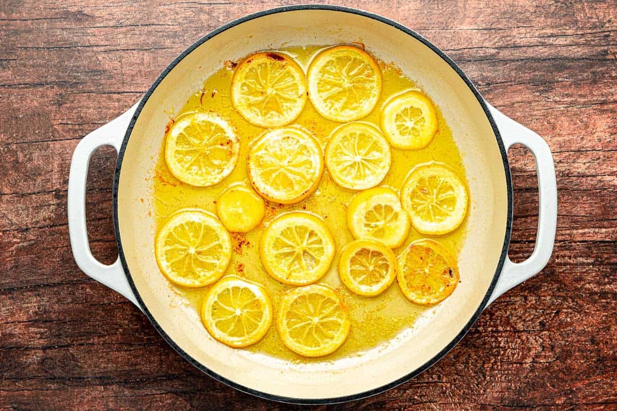 slices of lemons frying in olive oil in a skillet.