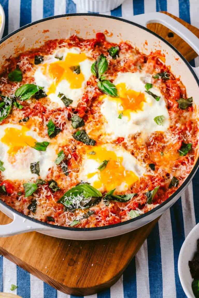 Cooked eggs in purgatory in a skillet on a serving board.