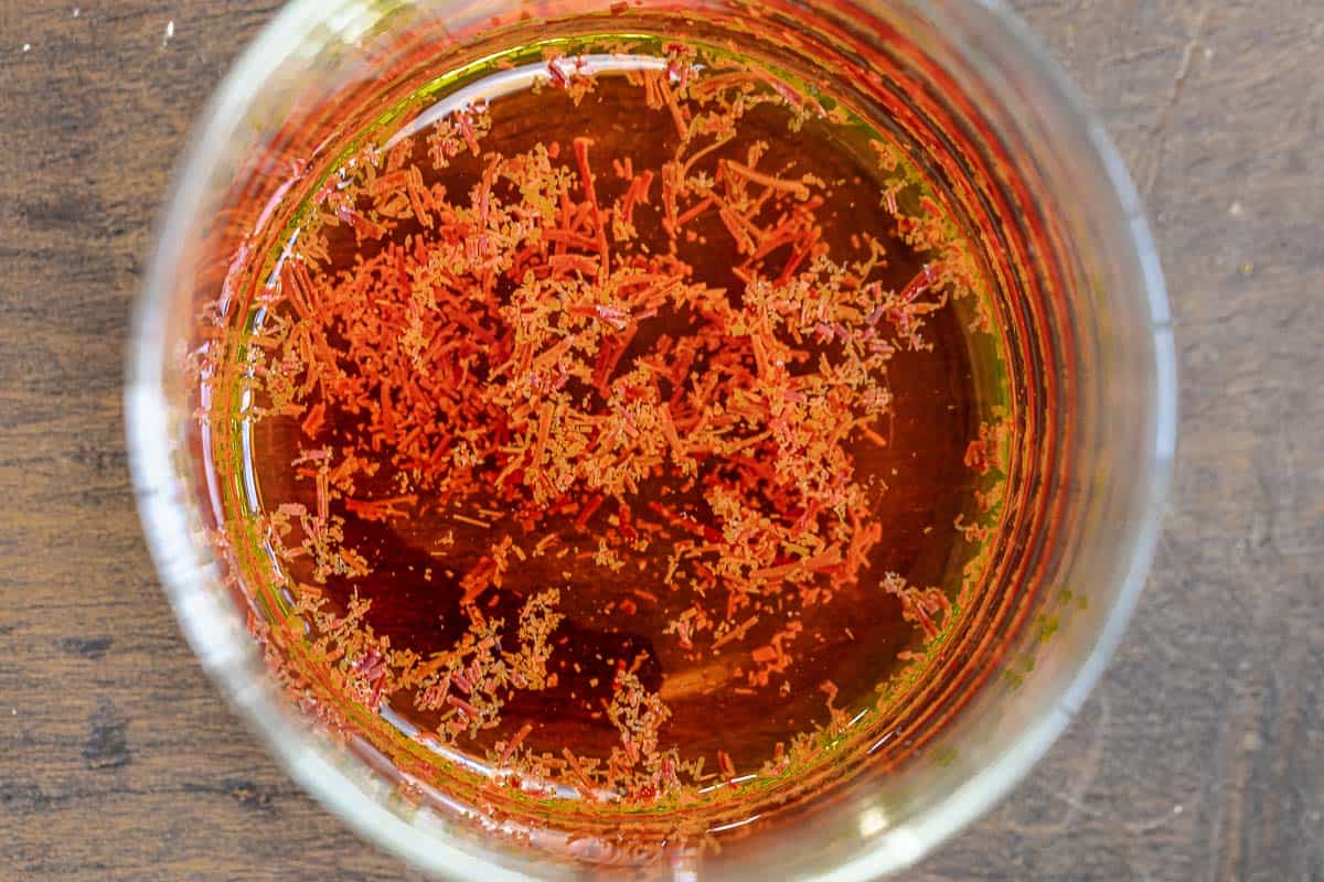 saffron threads blooming in a glass of water.