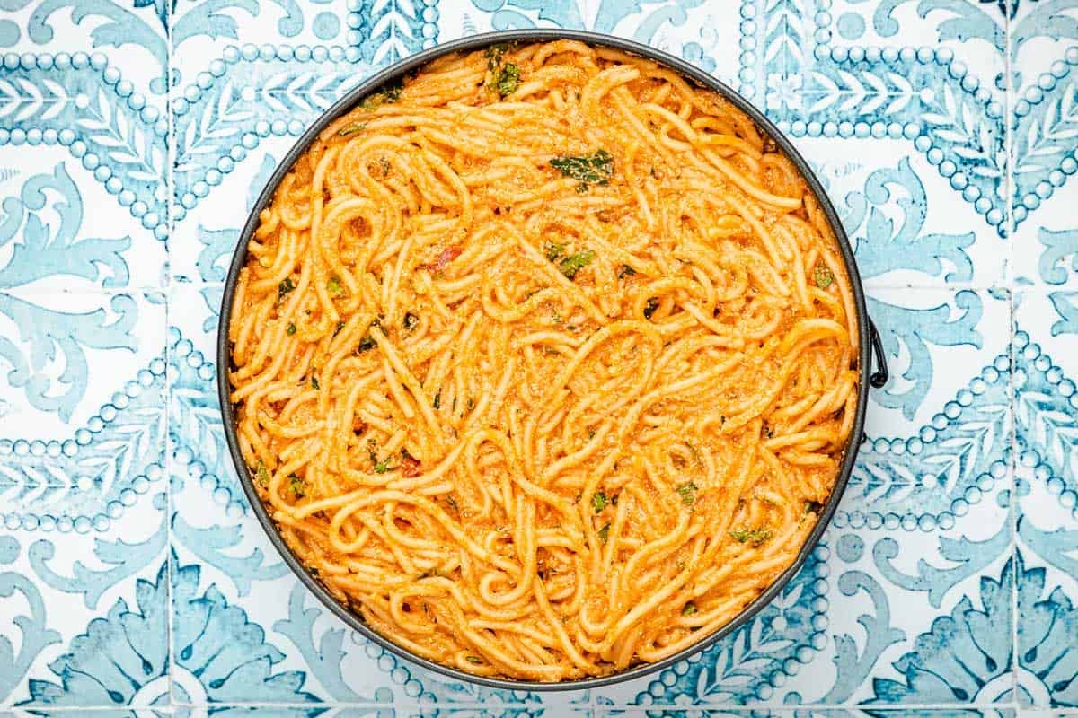 spaghetti pie in a spring form pan before cooking.