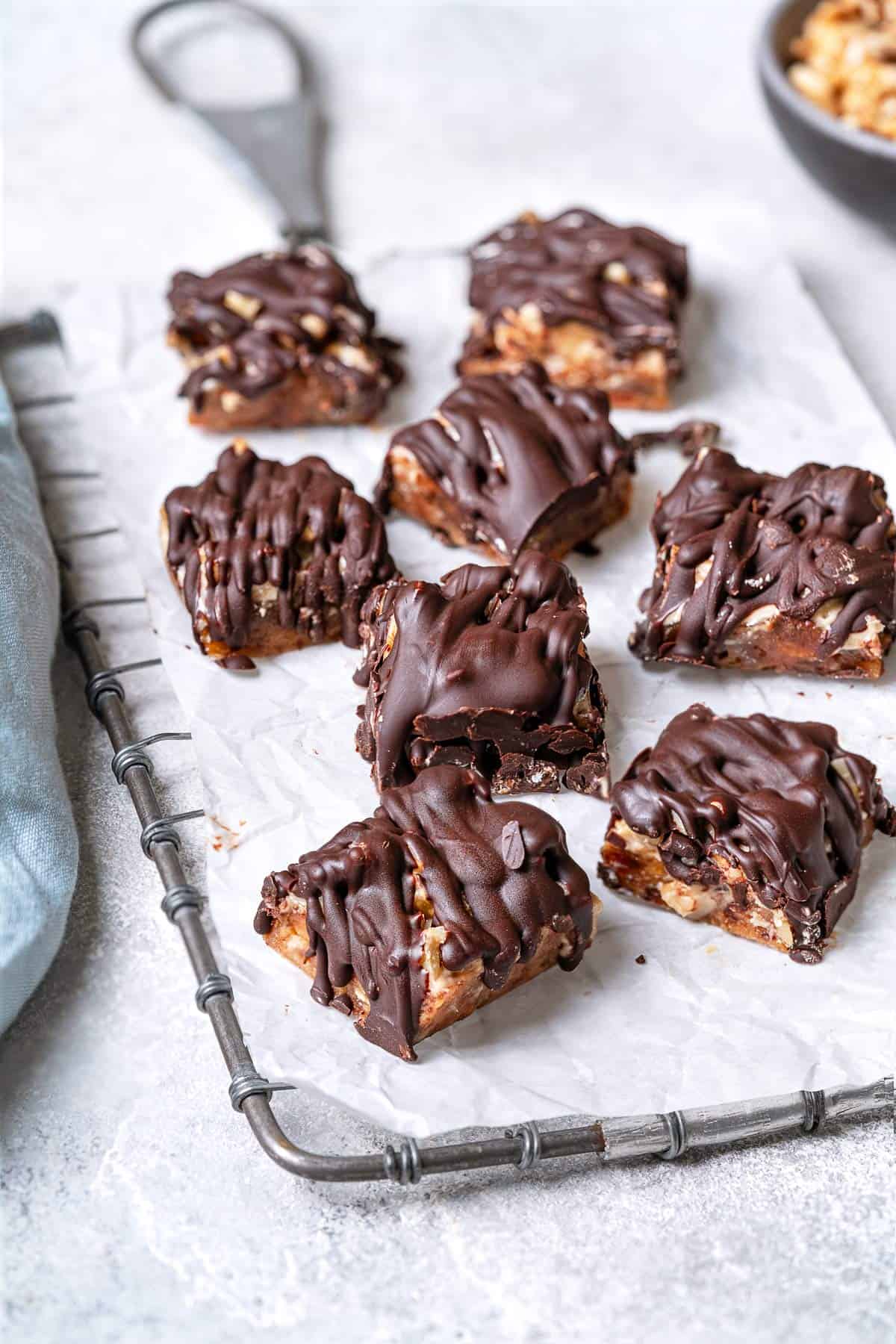 8 chocolate covered date bars on a parchment-lined serving tray.