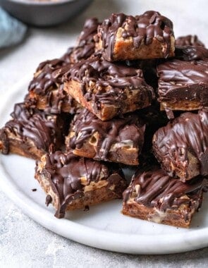 chocolate covered date bars stacked on a plate.