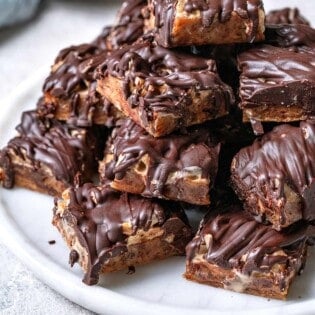 chocolate covered date bars stacked on a plate.