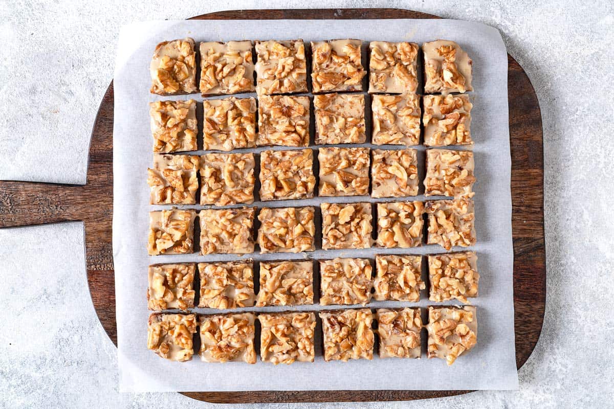 sliced date bars on a parchment-lined wooden serving tray.