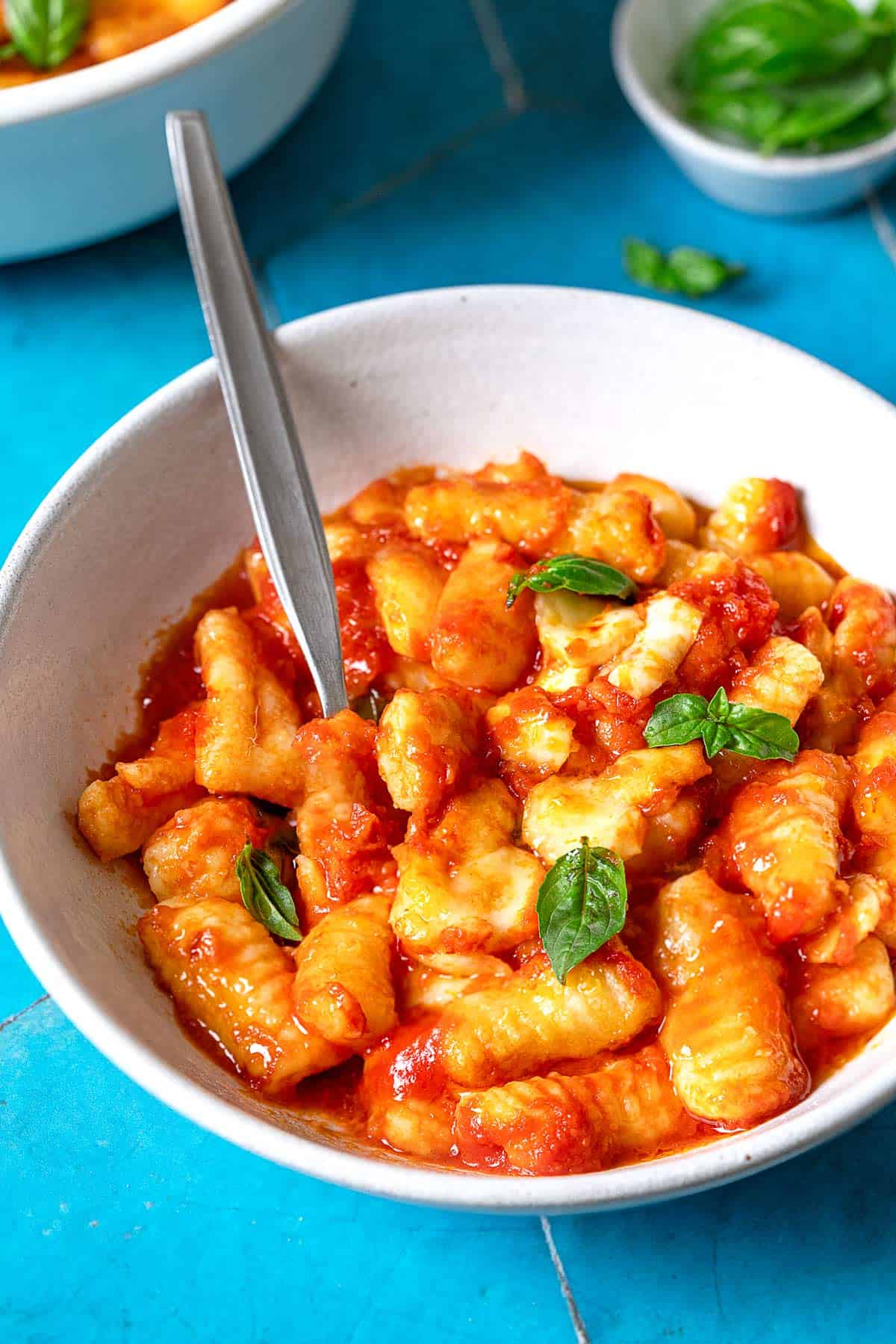 Bowl of Gnocchi alla Sorrentina with a metal spoon.