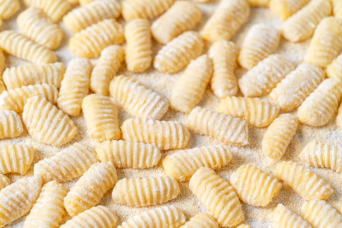 Close up of shaped and ridged potato gnocchi that have been dusted with semolina flour.