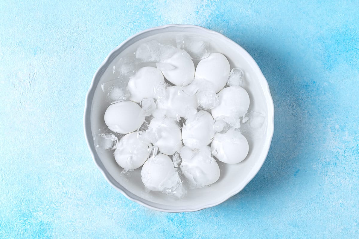 12 hard boiled eggs in a bowl of ice water.