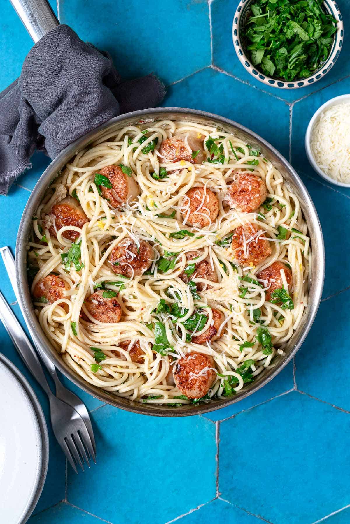 Large pan with scallop pasta and a sprinkle of parmesan cheese on top.