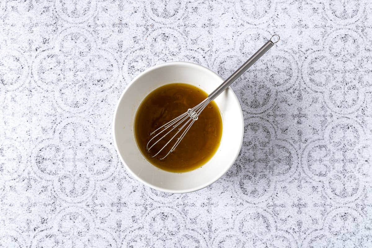 salad dressing in a bowl with a whisk.