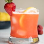 a glass of strawberry lemonade garnished with a strawberry and a lemon slice.