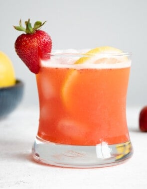 a glass of strawberry lemonade garnished with a strawberry and a lemon slice.