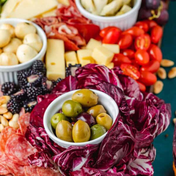 close up of a large antipasto platter with a selection of meats, cheeses, fruits, vegetables and nuts.