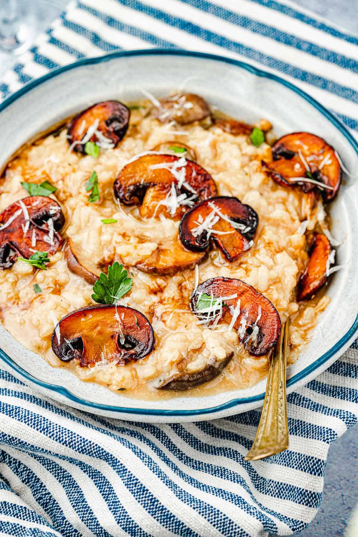 a bowl of mushroom risotto with a spoon.