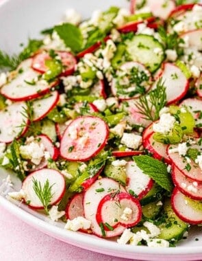 close up of cucumber and radish salad in a bowl.