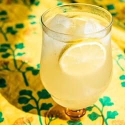 closeup of a limoncello spritz garnished with slices of lemon in an ice-filled glass.