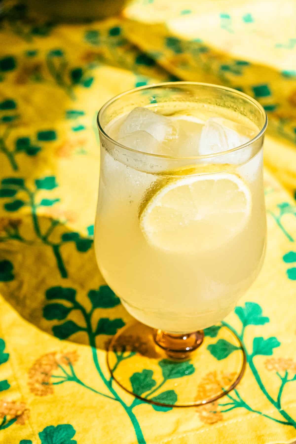 closeup of a limoncello spritz garnished with slices of lemon in an ice-filled glass.