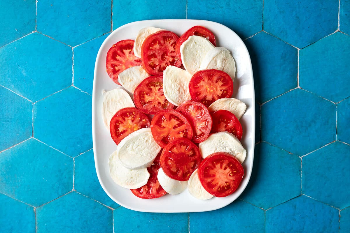 tranches de tomates et de mozzarella sur une assiette.