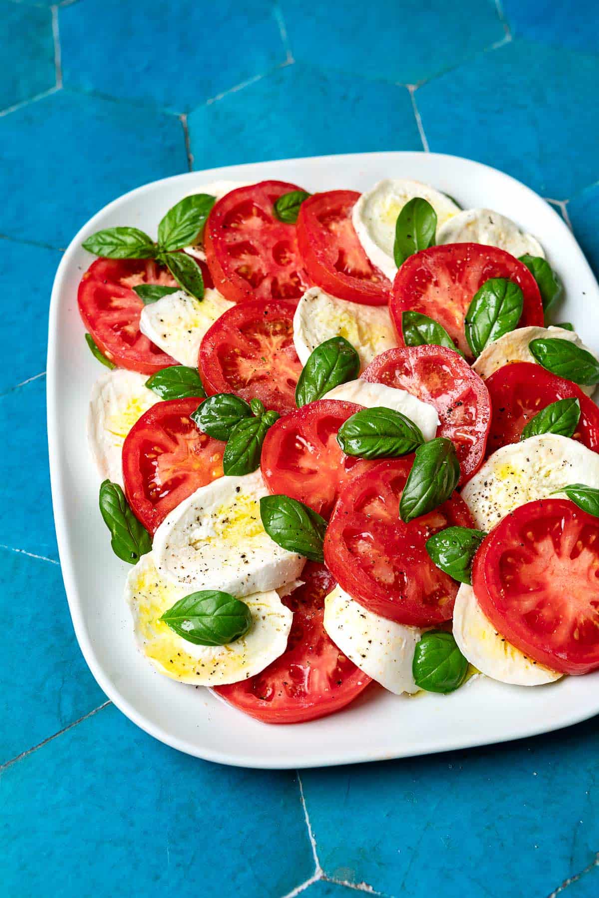 une salade caprese sur un plateau.