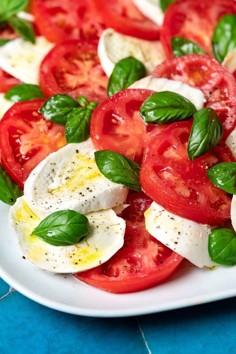 A caprese salad on a white platter.