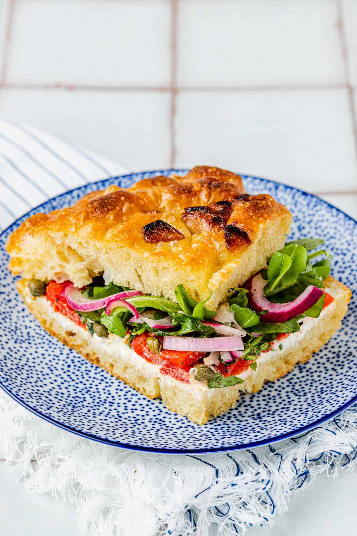 close up of one focaccia sandwich on a plate.