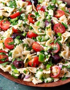 close up of a greek pasta salad in a serving bowl.