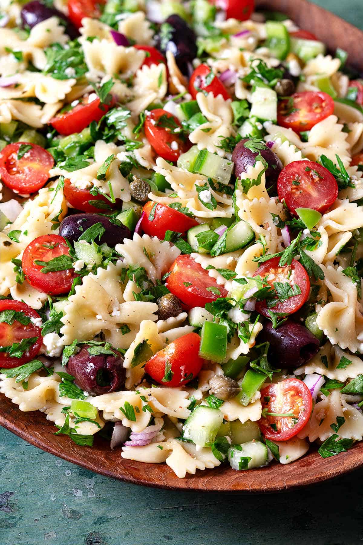 close up of a greek pasta salad in a serving bowl.