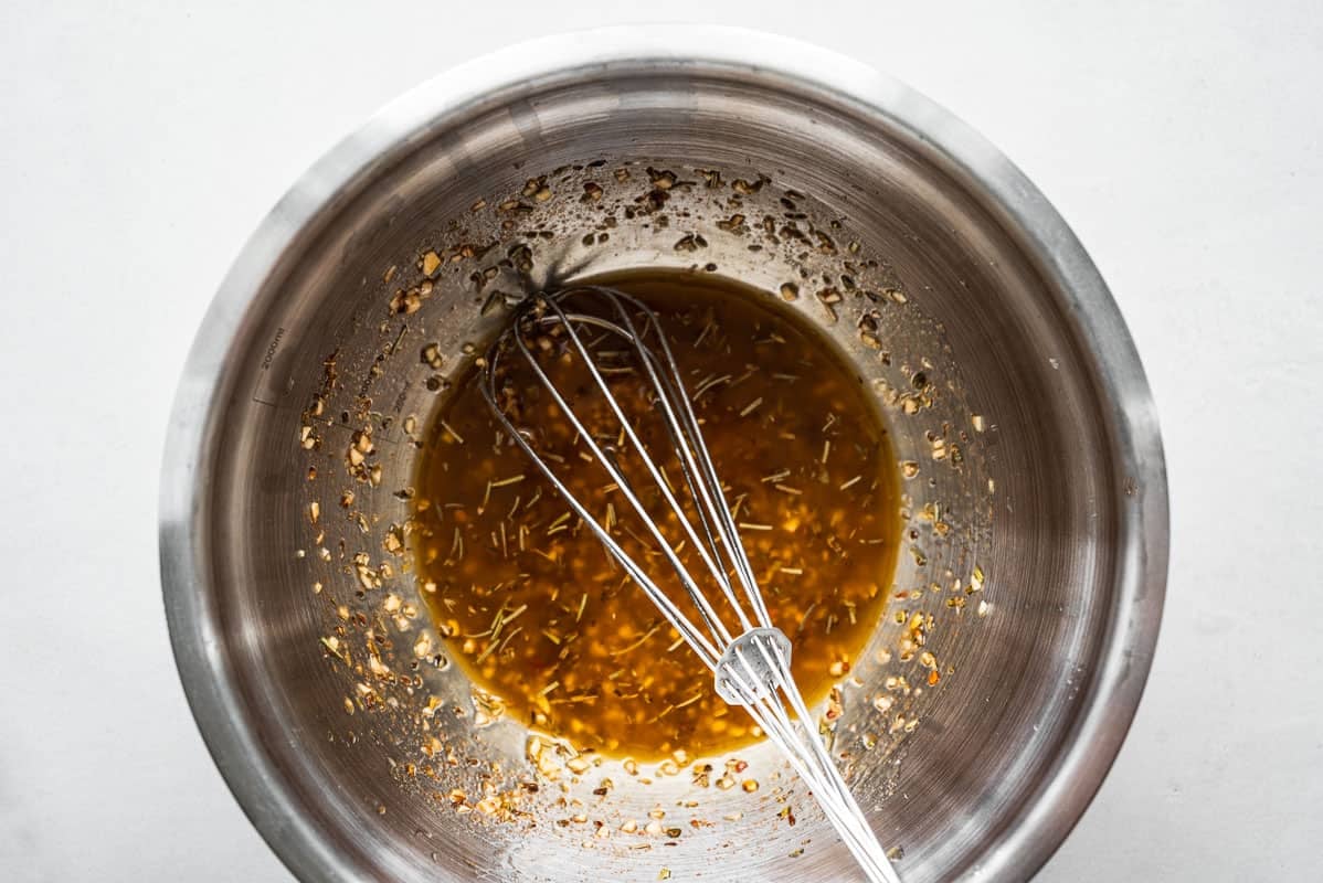 marinade being mixed in a bowl with a whisk.