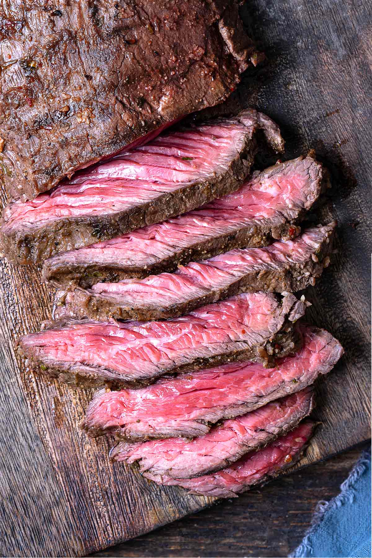 a sliced grilled skirt steak on a wooden cutting board.