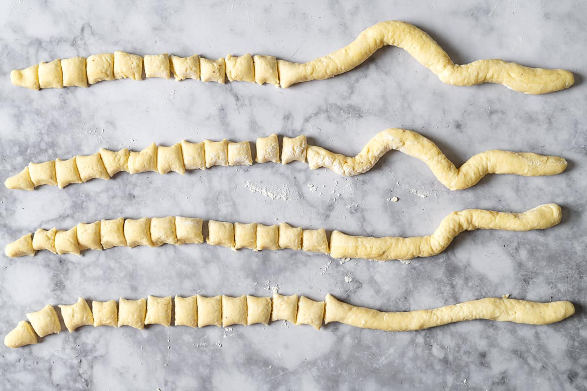 4 ropes of ricotta gnocchi dough with half of each cut into small pieces.