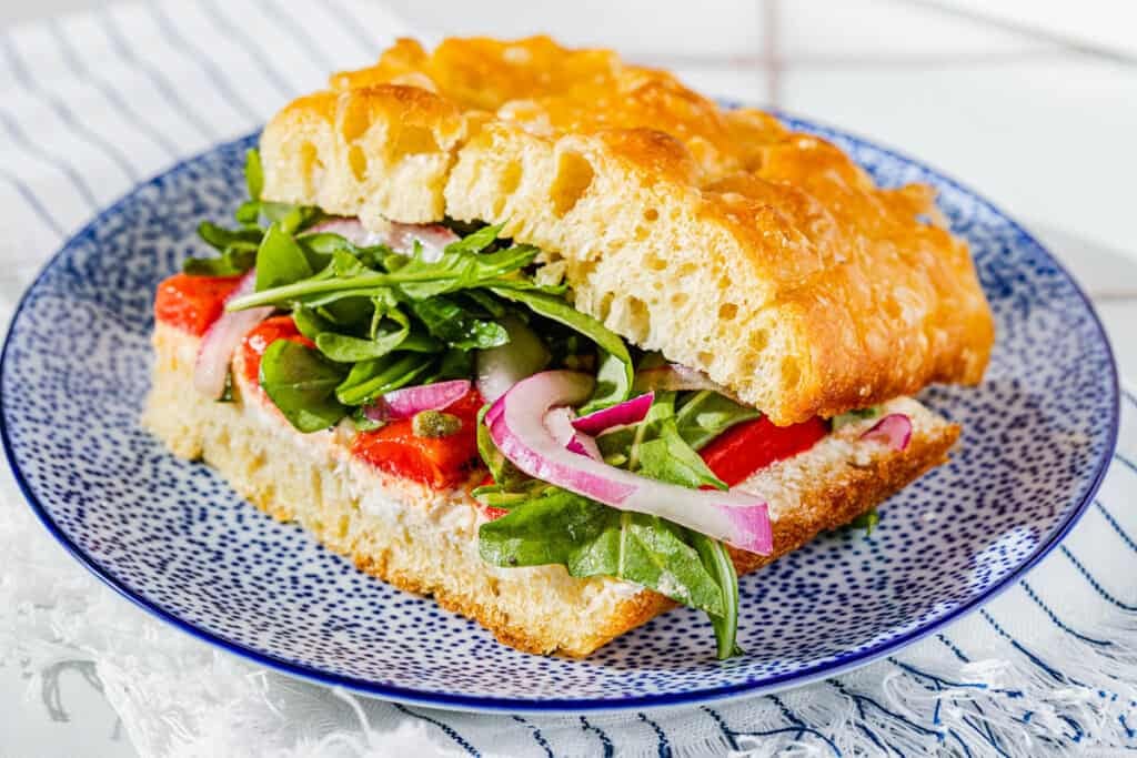 close up of one focaccia sandwich on a plate.
