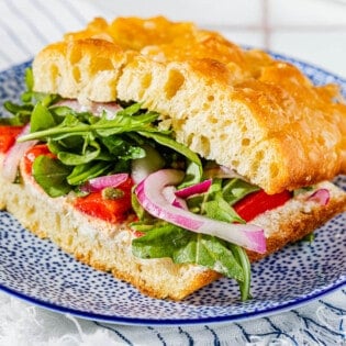 close up of one focaccia sandwich on a plate.