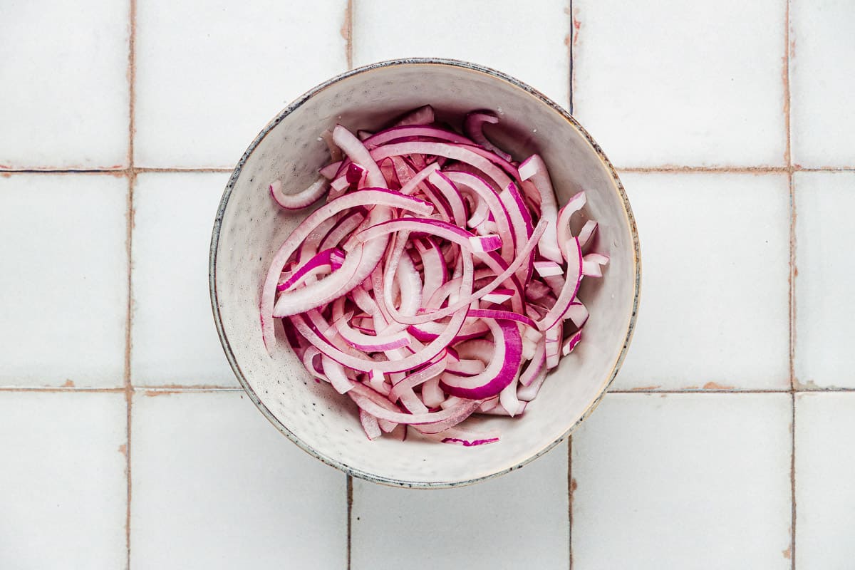 a bowl of thinly sliced red onions.