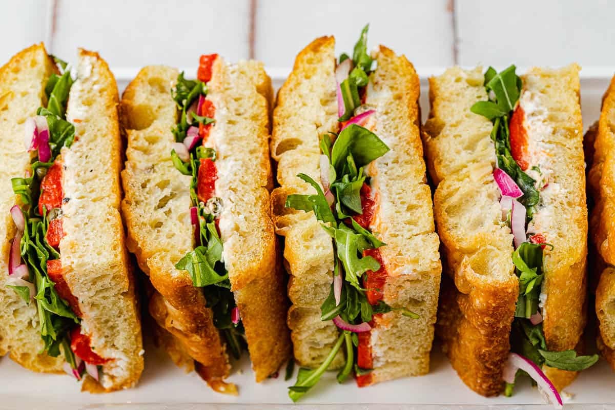 4 focaccia sandwiches in a row on a platter.