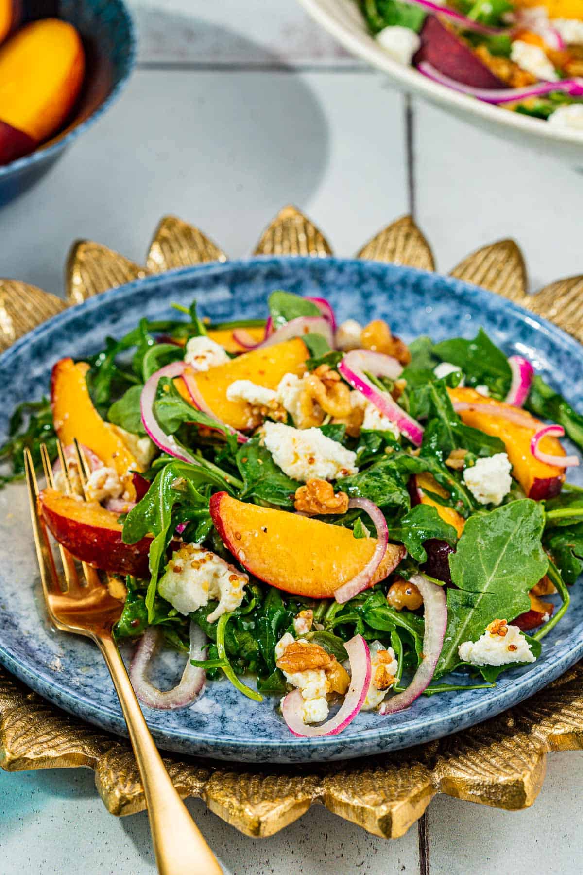 gros plan de salade de pêches sur une assiette avec une fourchette.