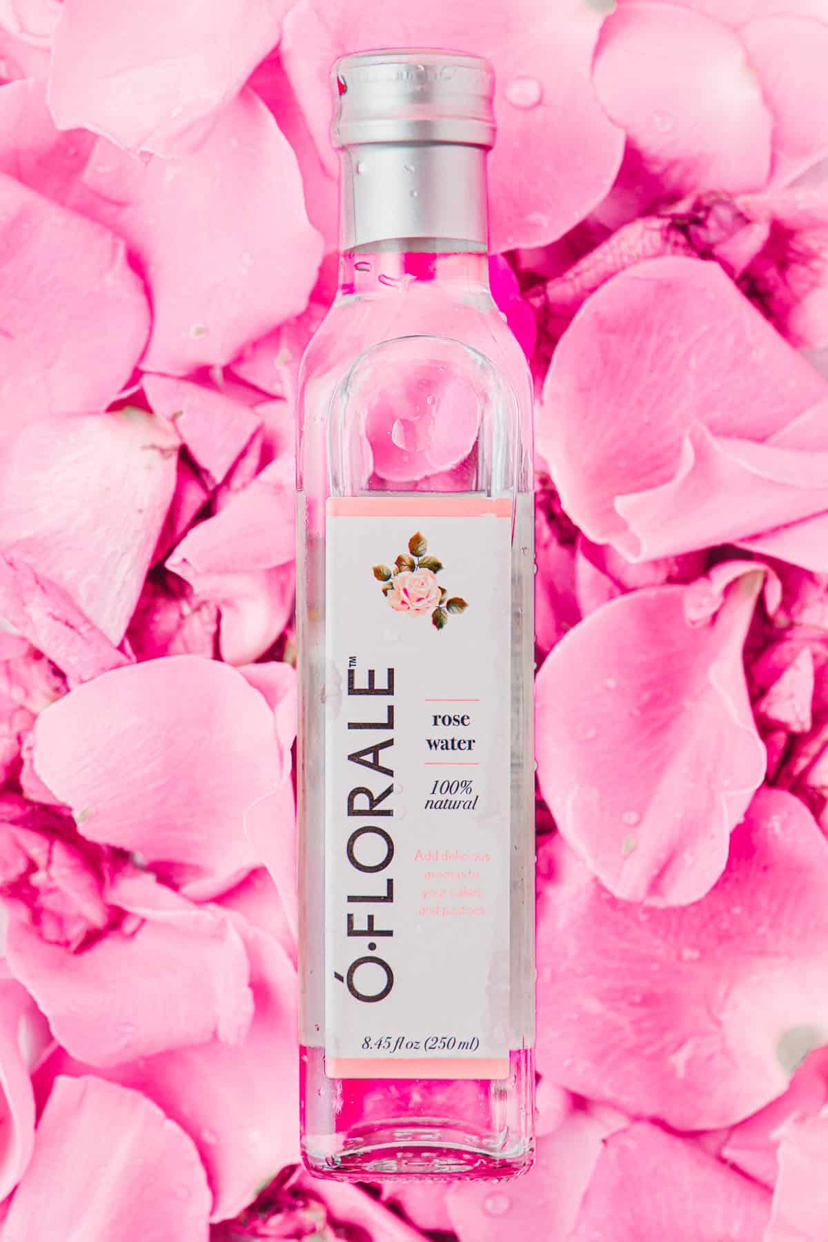 a bottle of o'florale rose water on a bed of pink rose petals.