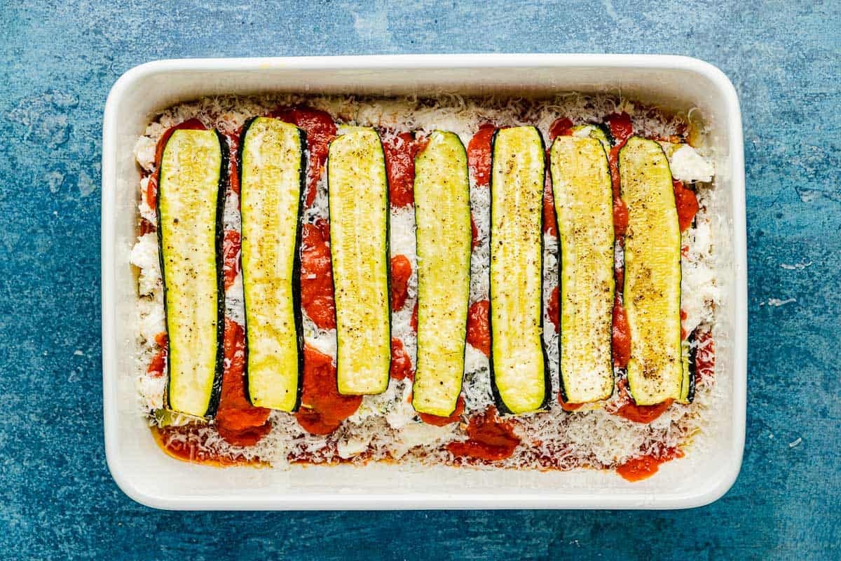 an entire un-baked zucchini parmesan in a baking dish.